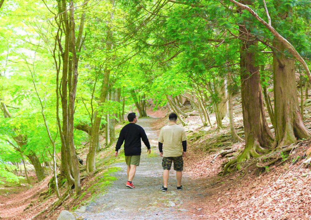 deux hommes marchant sur un chemin dans les bois dans l'établissement Hatago Nagomi, à Nikkō