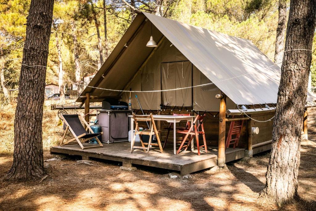 une tente avec une table et des chaises dans les bois dans l'établissement Camping Olva ***, à Sartène 20 autres photos