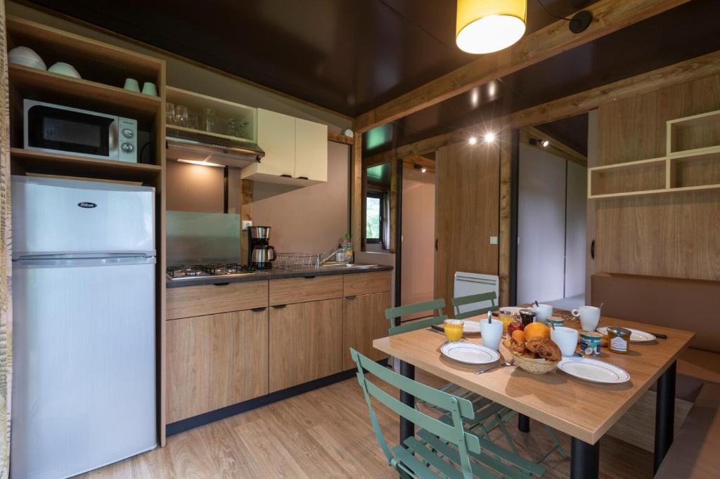 Il comprend une cuisine et une salle à manger avec une table en bois. dans l'établissement CityKamp Lyon, à Dardilly 26 autres photos