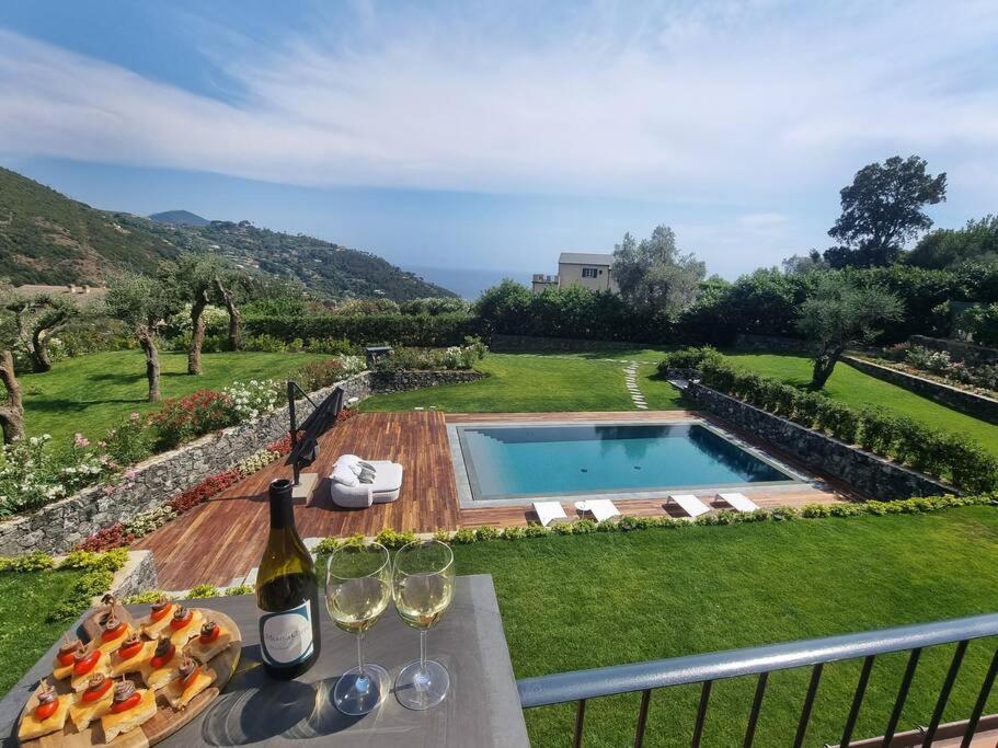 - une table avec des verres à vin et une bouteille de vin dans l'établissement Villa al Cio, Bonassola, à Bonassola