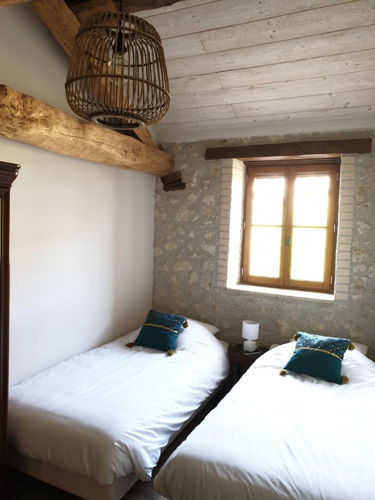 deux lits dans une chambre avec une fenêtre dans l'établissement Gite La Halippe, à Caussens 29 autres photos