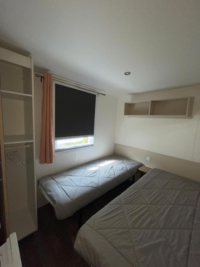 une petite chambre avec un lit et une fenêtre dans l'établissement Valras-Plage, les sables du midi ,mobil home, à Sérignan 1 autre photo