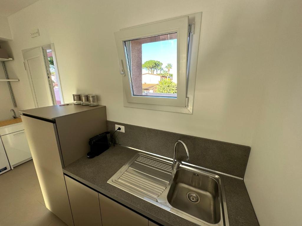 une cuisine avec un évier et une fenêtre dans l'établissement Rubino apparthotel - Portorosa, à Furnari