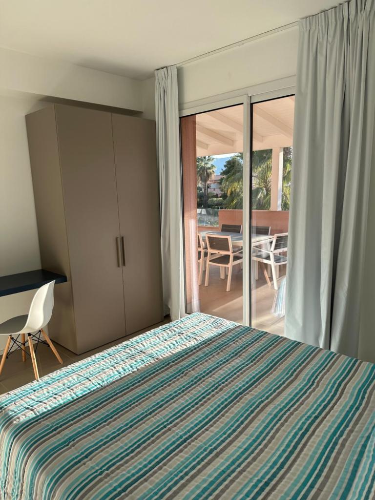 une chambre avec un lit et une porte coulissante en verre dans l'établissement Rubino apparthotel - Portorosa, à Furnari