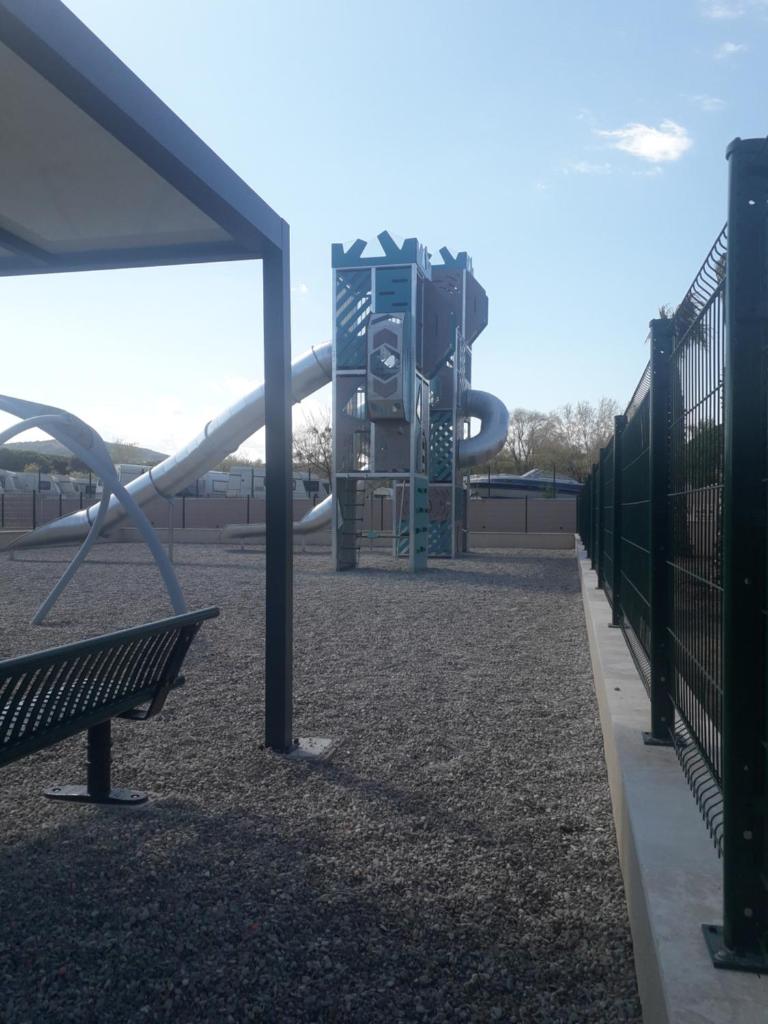 - une aire de jeux avec toboggan et banc dans un parc dans l'établissement mobil home neuf 2 chambres 6 personnes Saint Aygulf plage, à Fréjus