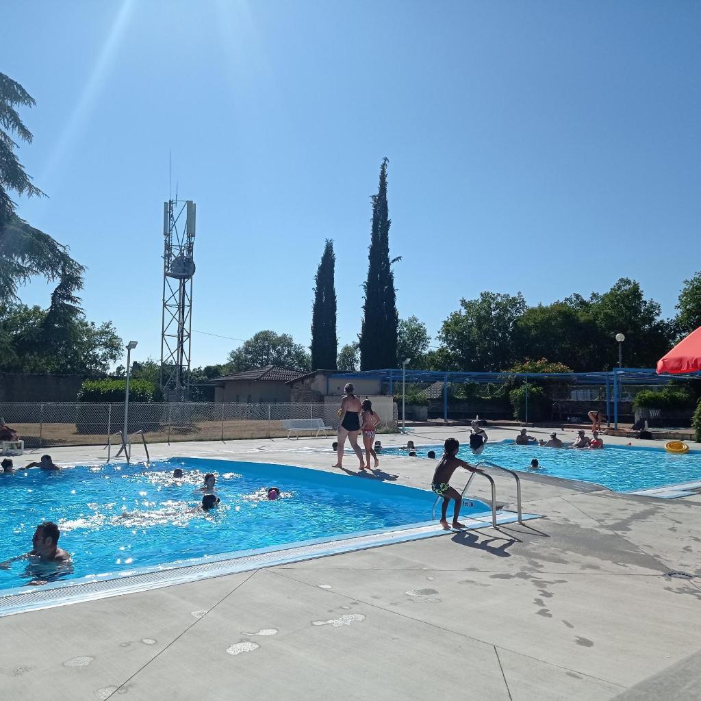 un groupe de personnes dans une piscine dans l'établissement CAMPING LE BEL AIR- Mobil home le laurier, à Limogne-en-Quercy