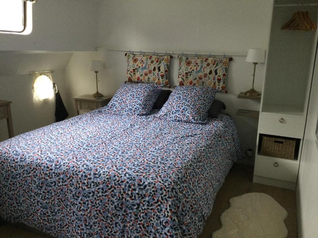 - une chambre avec un lit doté d'une couette et d'oreillers bleus dans l'établissement Péniche GEMJO, à Castelsarrasin 4 autres photos
