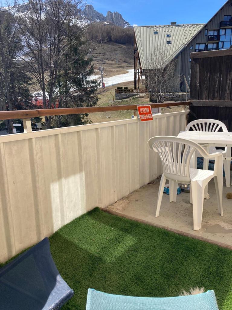 une cour avec une clôture, une table et des chaises dans l'établissement APPARTEMENT MONTAGNE, à Réallon 3 autres photos