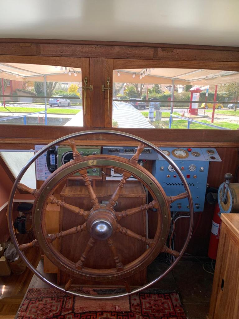 un volant de direction en bois sur un bateau dans l'établissement Péniche GEMJO, à Castelsarrasin
