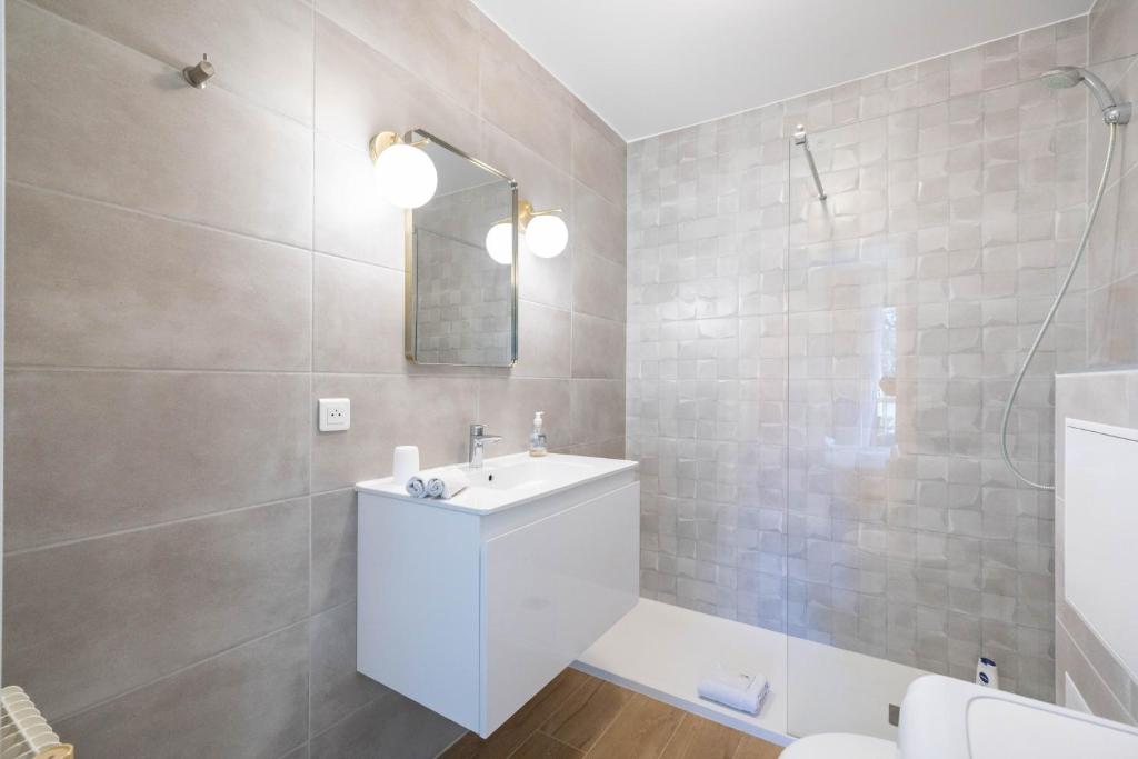 une salle de bain avec un lavabo blanc et une douche dans l'établissement Spacious apartment at a 5 min walk from the beach, à Antibes