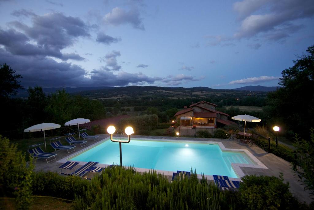 - une piscine avec chaises longues et parasols la nuit dans l'établissement Podere Varlunga, à Borgo alla Collina 10 autres photos