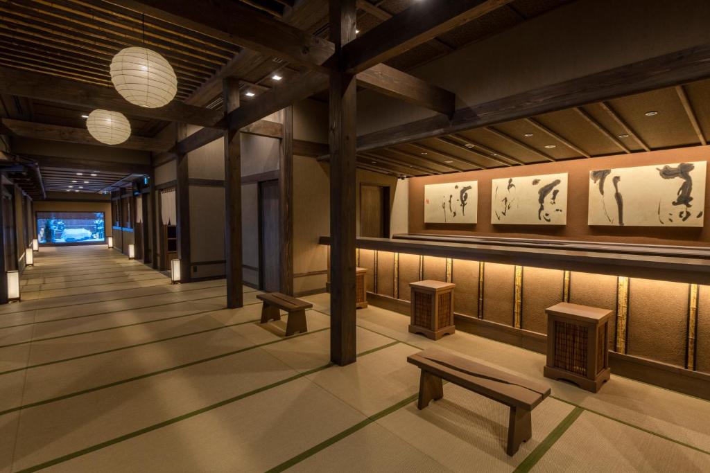 un couloir avec des bancs et des peintures sur les murs dans l'établissement Jozankei Onsen Yurakusoan, à Jozankei 37 autres photos