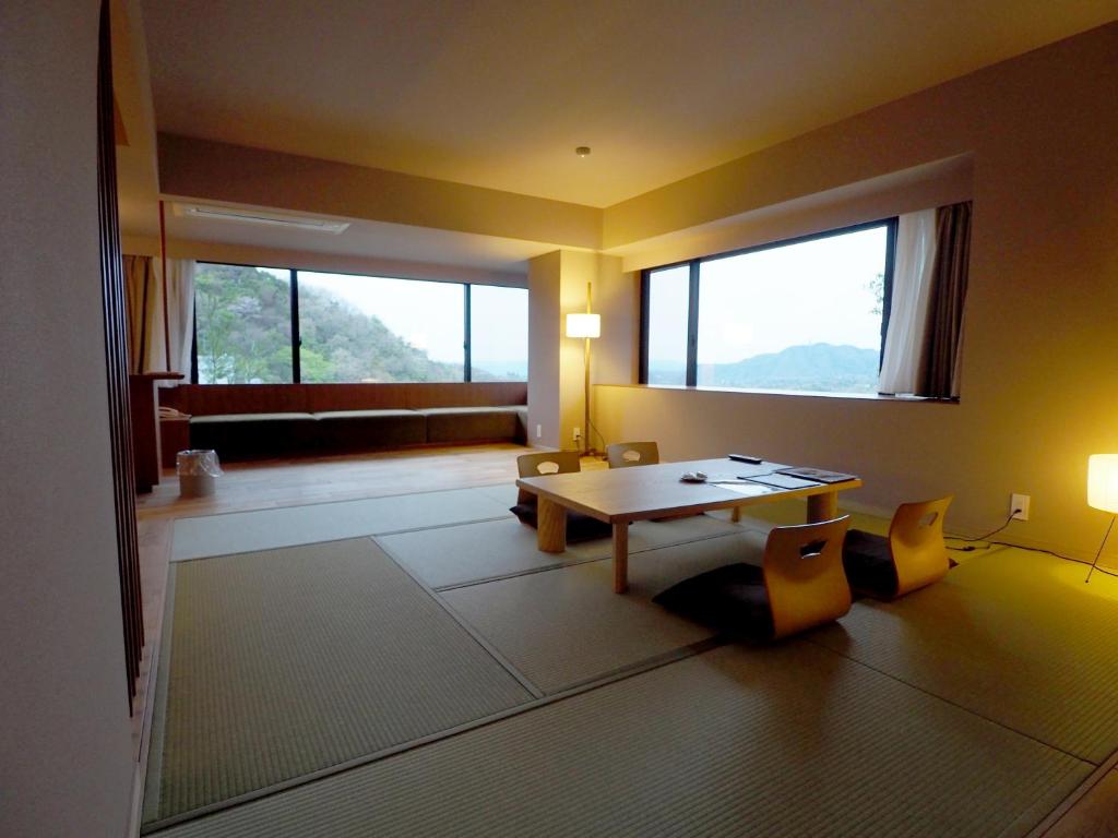 un salon avec une table et une grande fenêtre dans l'établissement Negiya Ryofukaku, à Kobe