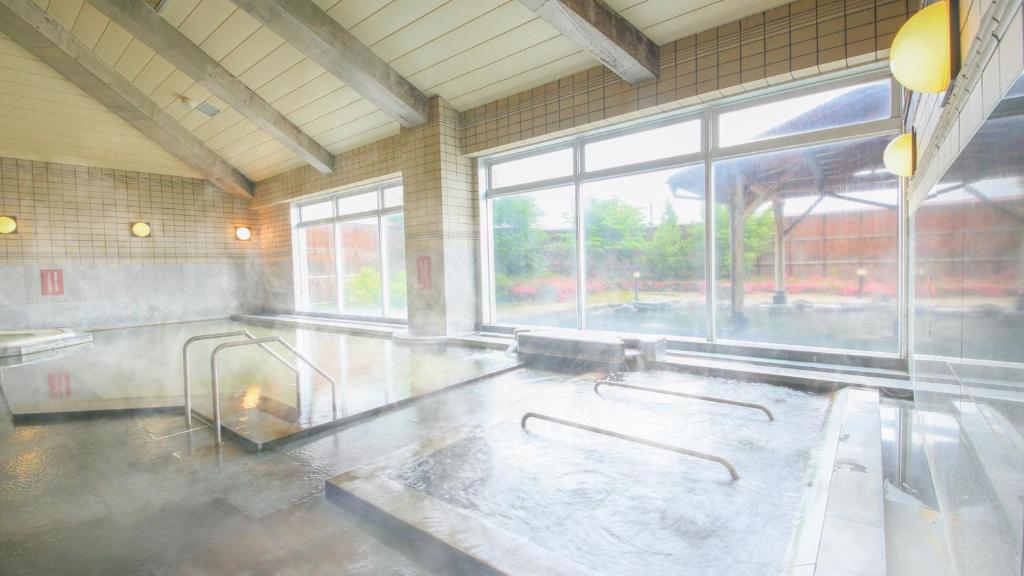 Cette grande chambre dispose d'une grande fenêtre et d'une baignoire. dans l'établissement Ooedo Onsen Monogatari Aizu, à Aizuwakamatsu