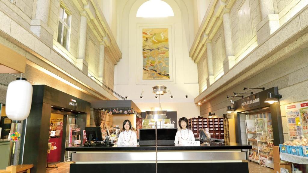 un magasin avec deux femmes debout derrière un comptoir dans un magasin dans l'établissement Ooedo Onsen Monogatari Aizu, à Aizuwakamatsu