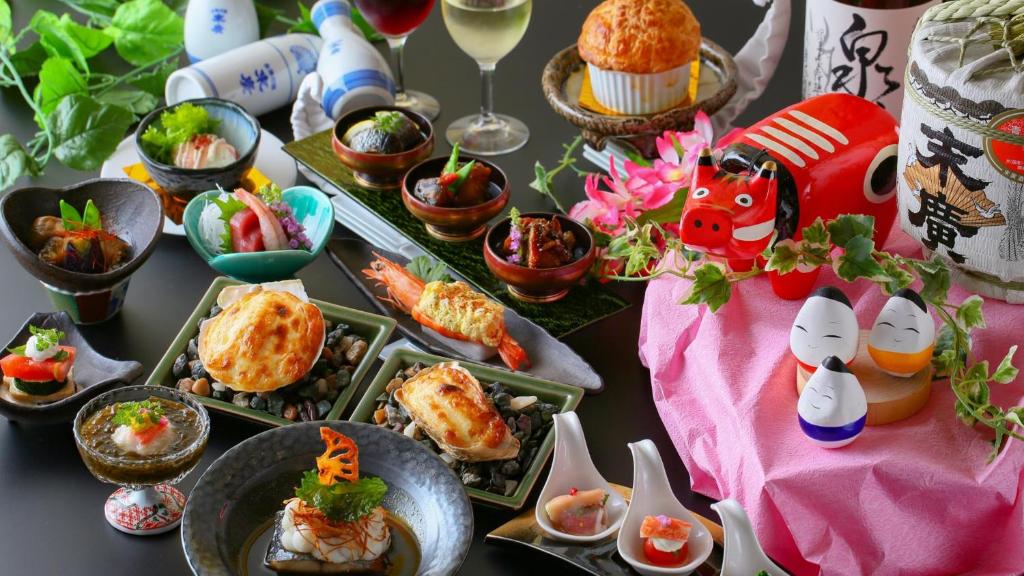 - une table avec des plats et du vin dans l'établissement Ooedo Onsen Monogatari Aizu, à Aizuwakamatsu