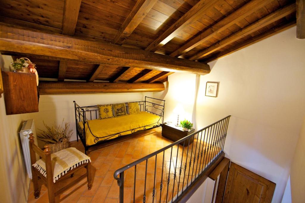 - un salon avec un lit jaune dans l'établissement Podere Varlunga, à Borgo alla Collina
