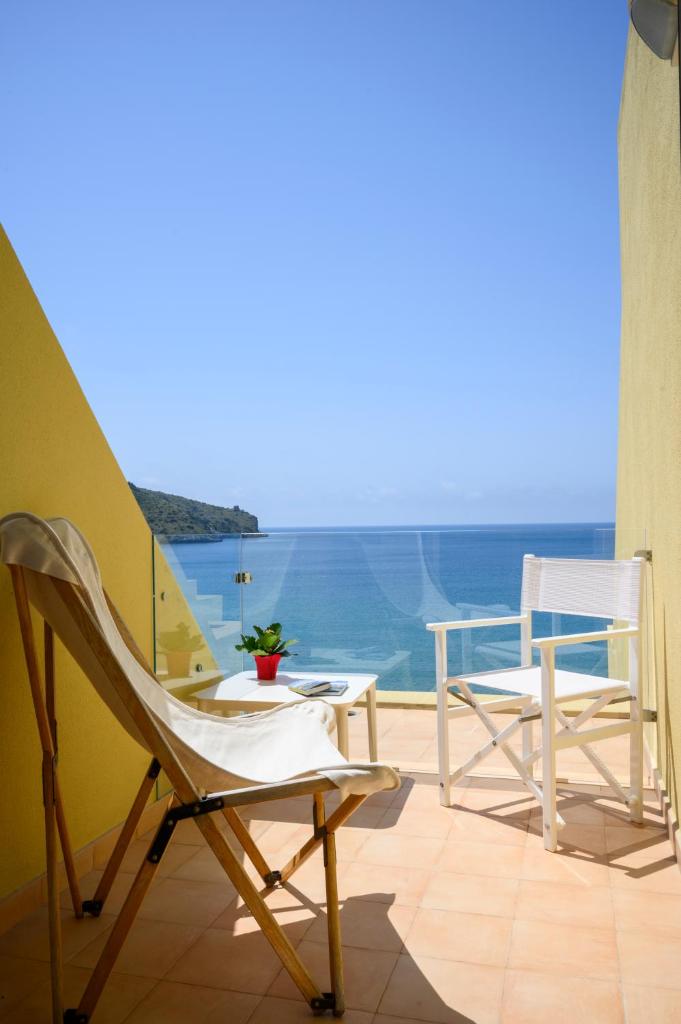 un balcon avec deux chaises et une vue sur l'océan dans l'établissement Grand Hotel San Pietro, à Palinuro