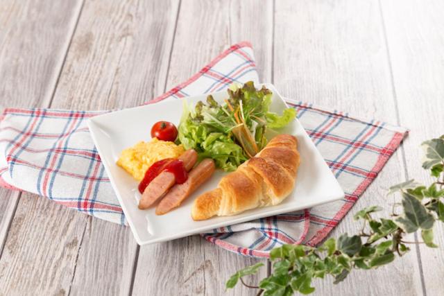 une assiette de nourriture avec des hot-dogs et une salade dans l'établissement ホテルDEN, à Tokyo 1 autre photo