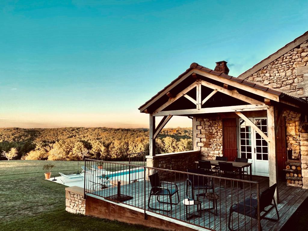 une maison en pierre avec une terrasse et une piscine dans l'établissement Domaine de Cazal - Gîte 2 pers avec piscine au cœur de 26 hectares de nature préservée, à Saint-Cyprien