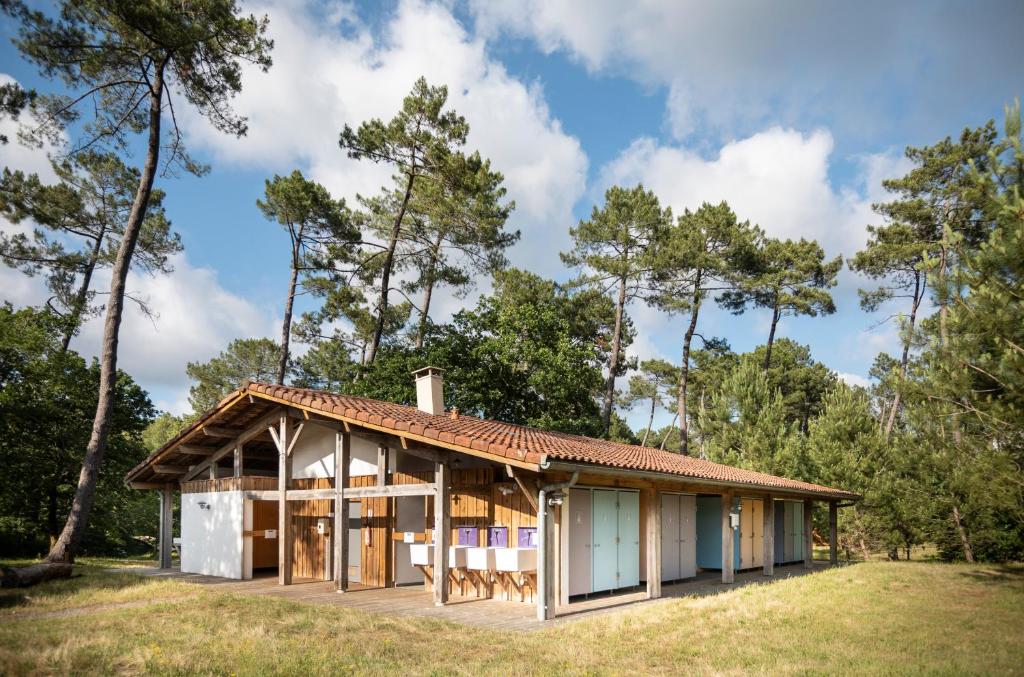 une maison dans les bois avec une serre dans l'établissement Huttopia Landes Sud, à Saint-Michel-Escalus