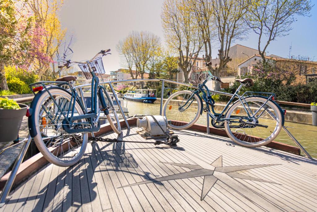 Deux vélos sont garés sur une terrasse en bois. dans l'établissement Bateau Le Nubian, à Narbonne