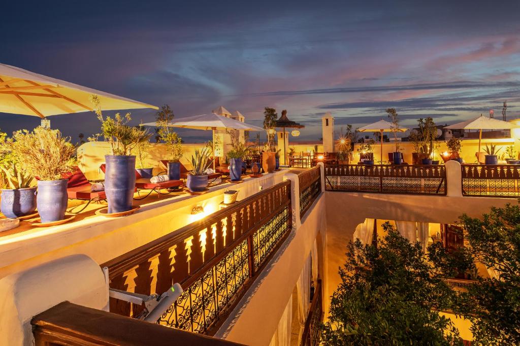 - un balcon avec des tables et des chaises dans l'établissement Riad Dar El Médina - Heated Swimming pool, jacuzzi & Spa, à Marrakech