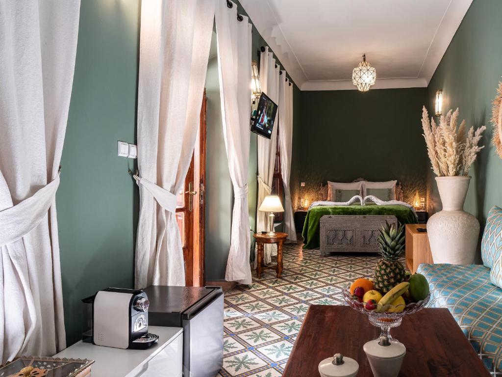 - un salon avec un lit et une corbeille de fruits sur une table dans l'établissement Riad Dar El Médina - Heated Swimming pool, jacuzzi & Spa, à Marrakech