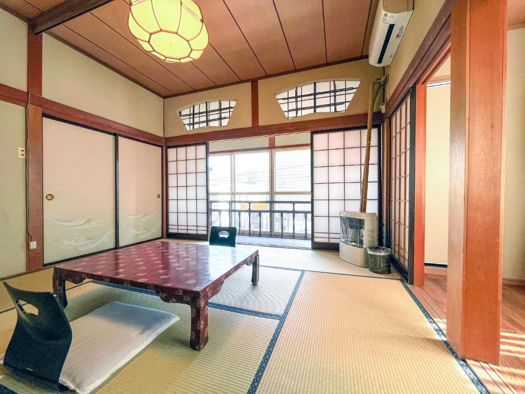 une pièce avec une table dans une pièce avec des fenêtres dans l'établissement Kobori Ryokan, à Hirosaki