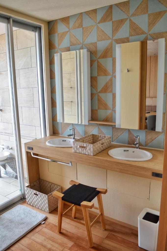 une salle de bain avec deux lavabos et un miroir dans l'établissement Shimoda Yamatokan, à Shimoda