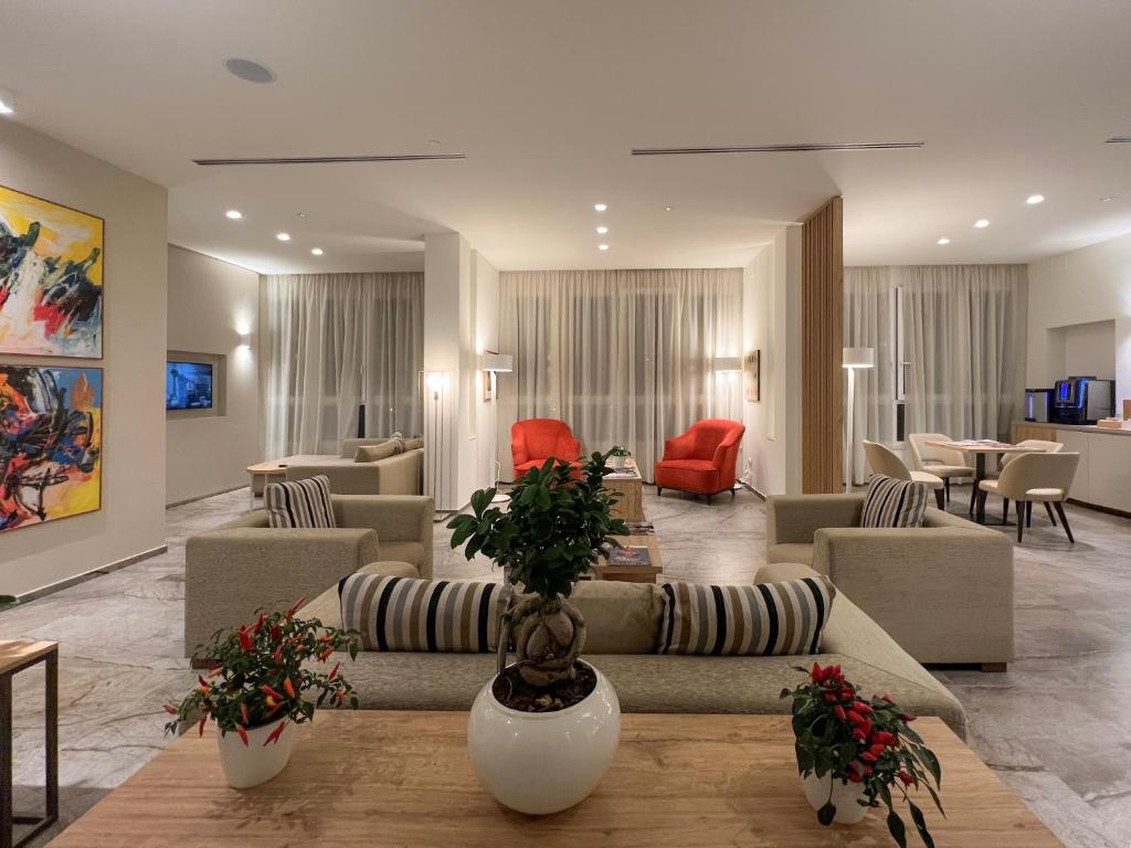 - un salon avec des canapés, des tables et des chaises dans l'établissement Hotel Rex, à Livourne