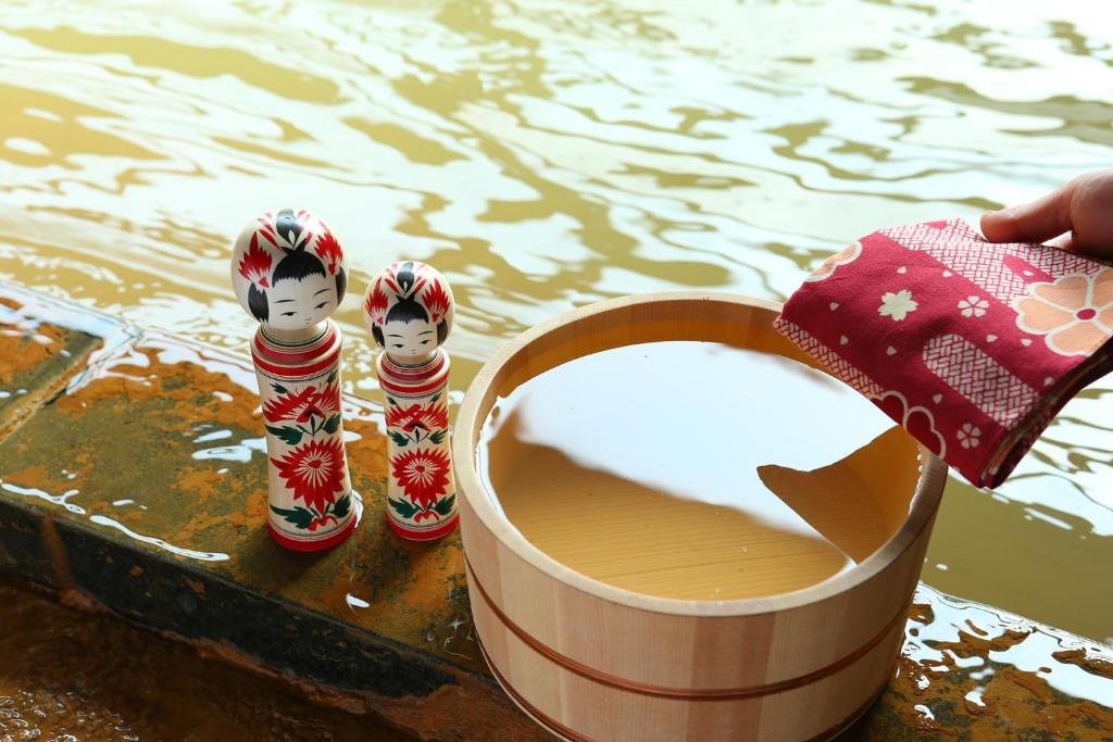 un récipient de lait à côté de deux poupées à côté de l'eau dans l'établissement Ooedo Onsen Monogatari Kounkaku, à Osaki 37 autres photos