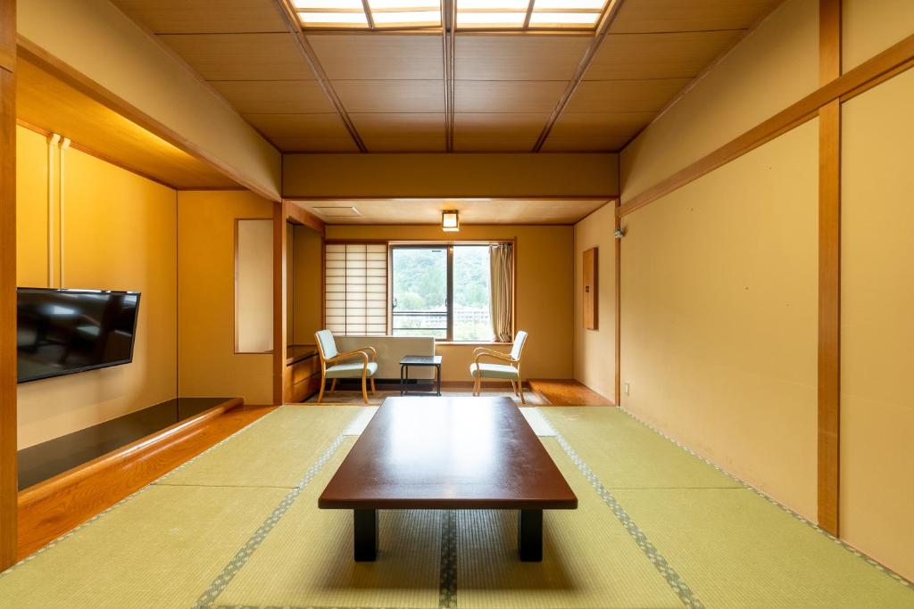 un salon avec une table et une télévision dans l'établissement Ooedo Onsen Monogatari Kounkaku, à Osaki
