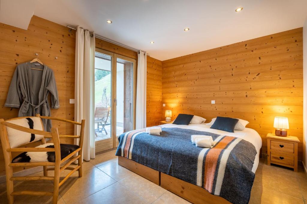 une chambre avec un lit et un mur en bois dans l'établissement Chalet le 4 - numéro 4, au Grand-Bornand 21 autres photos