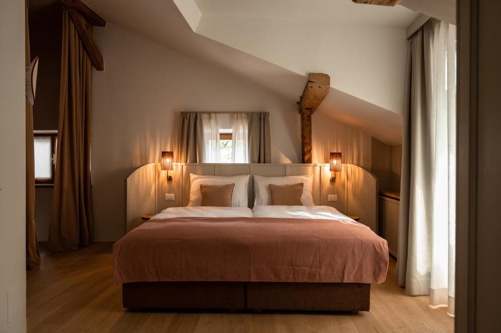 - une chambre avec un grand lit et deux lumières sur dans l'établissement Leuchtenburg am See, à Caldaro