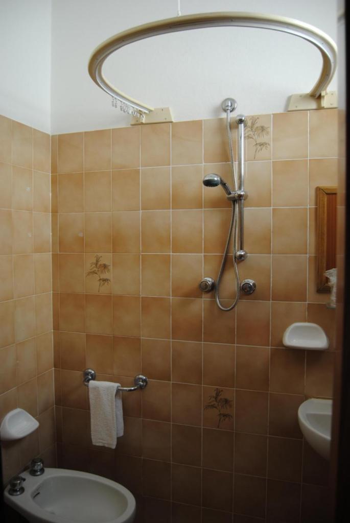 une salle de bain avec une douche, des toilettes et un lavabo dans l'établissement Hotel La Caravella, à Bellaria-Igea Marina