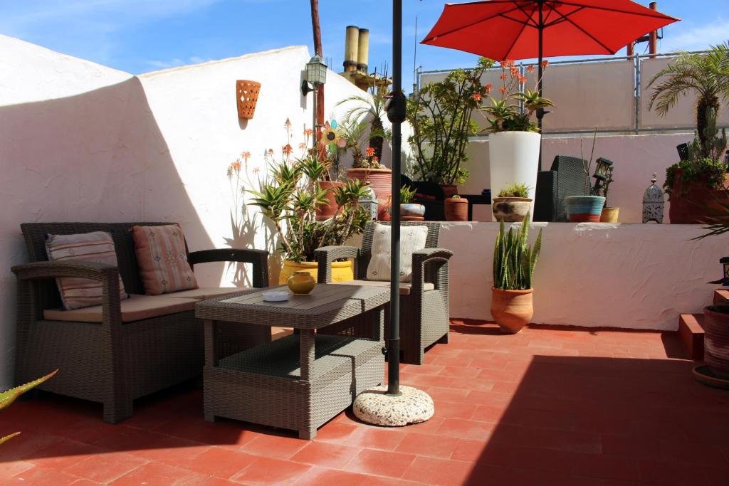 une terrasse avec une table, une chaise et un parasol dans l'établissement Riad Meftaha, à Rabat