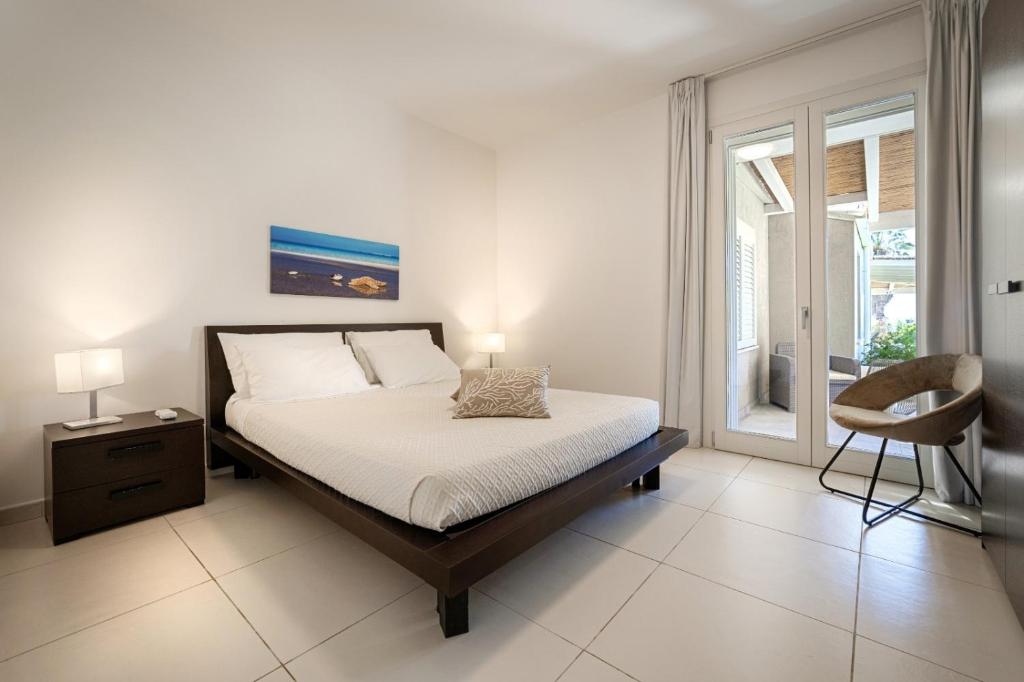une chambre avec un lit, une chaise et une fenêtre dans l'établissement Villa Aquarius, à Marina di Ragusa
