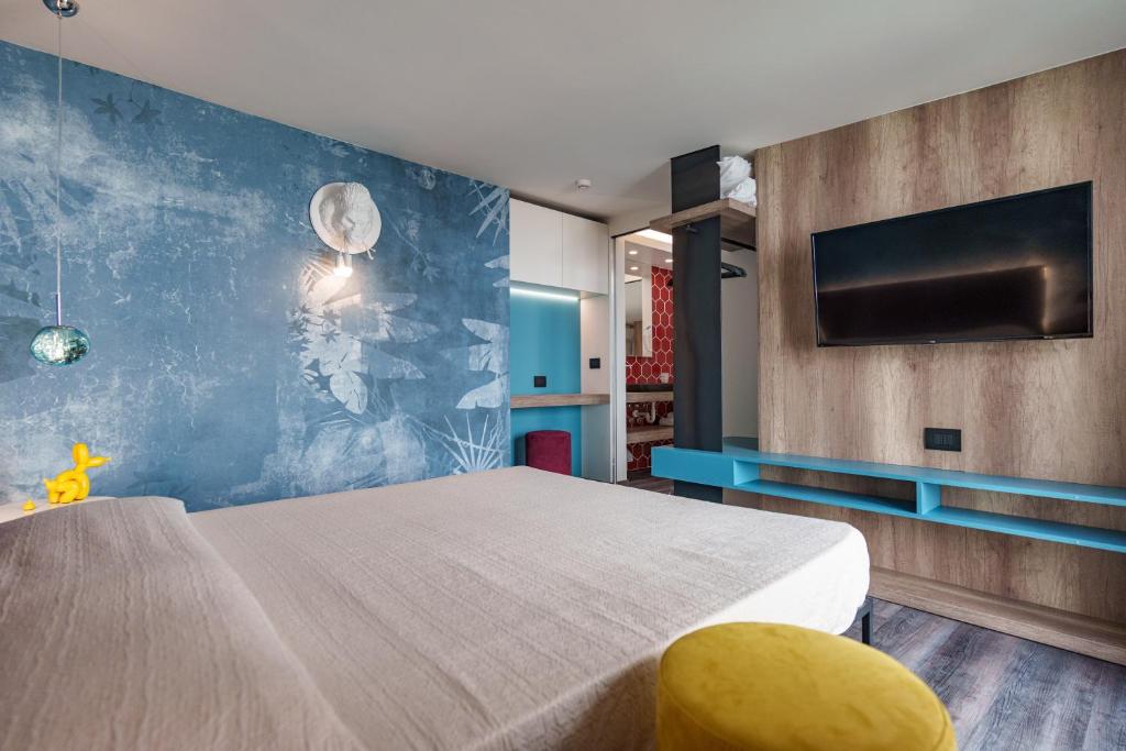 une chambre avec un grand lit et une télévision dans l'établissement Design Hotel Astra B&B, à Misano Adriatico