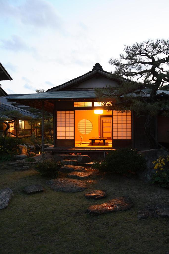 une maison japonaise avec une porte éclairée dans l'établissement Yoyokaku, à Karatsu