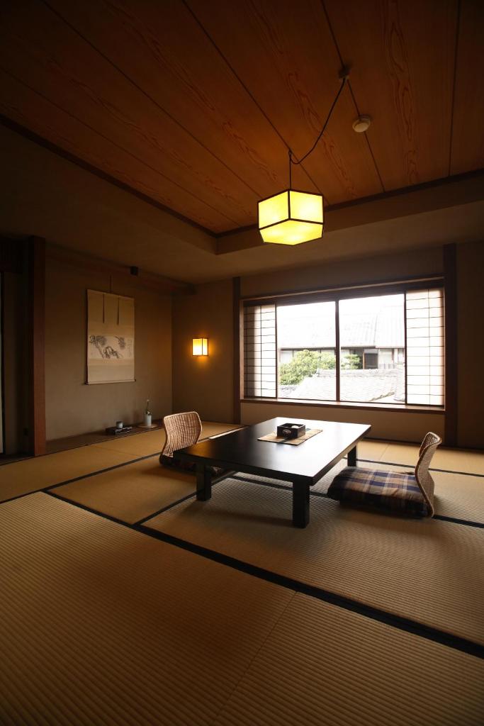 - un salon avec une table basse et une fenêtre dans l'établissement Yoyokaku, à Karatsu