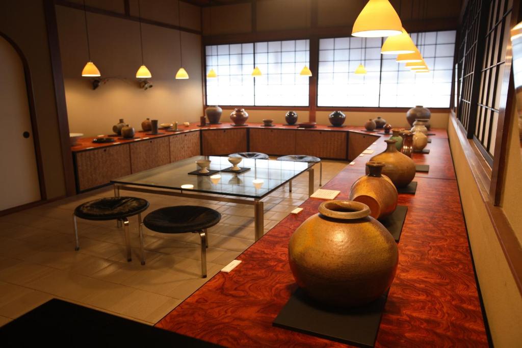 Cette grande chambre comprend un vase, une table et des chaises. dans l'établissement Yoyokaku, à Karatsu