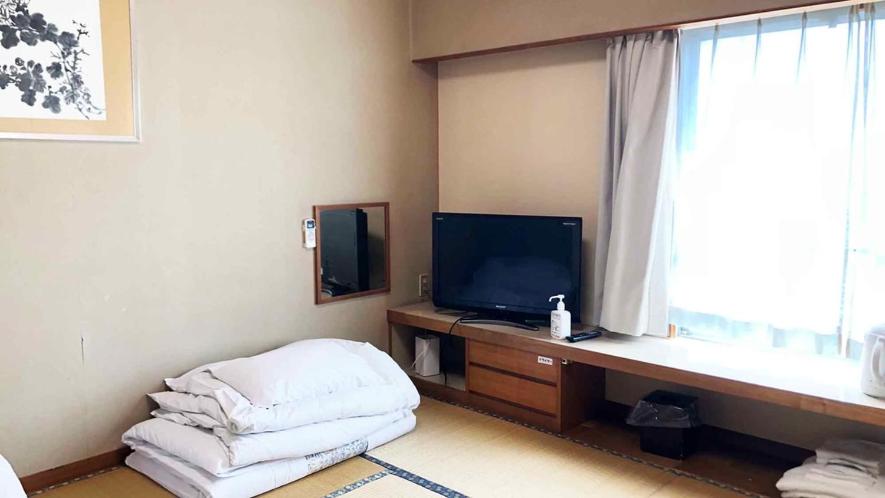 Cette chambre dispose d'une télévision et d'un bureau avec une fenêtre. dans l'établissement Kagetsu Ryokan, à Shizuoka