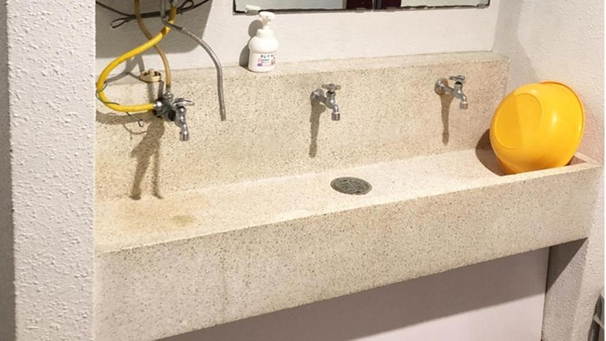 un lavabo de salle de bain avec trois robinets sur un mur dans l'établissement Kagetsu Ryokan, à Shizuoka 33 autres photos