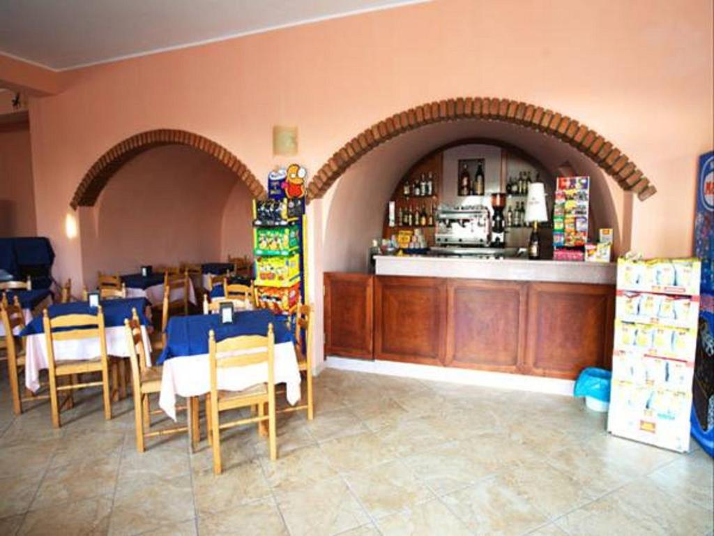 un restaurant avec un bar et quelques tables et chaises dans l'établissement Belvedere Hotel Club, à Belvedere Marittimo