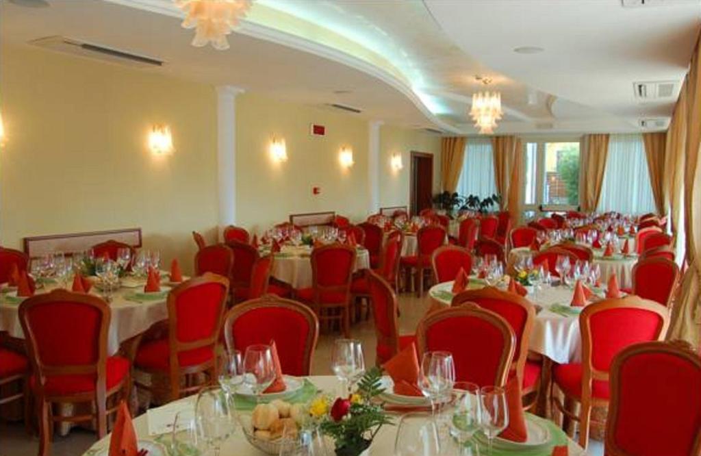 une salle remplie de tables et de chaises avec des chaises rouges dans l'établissement Belvedere Hotel Club, à Belvedere Marittimo