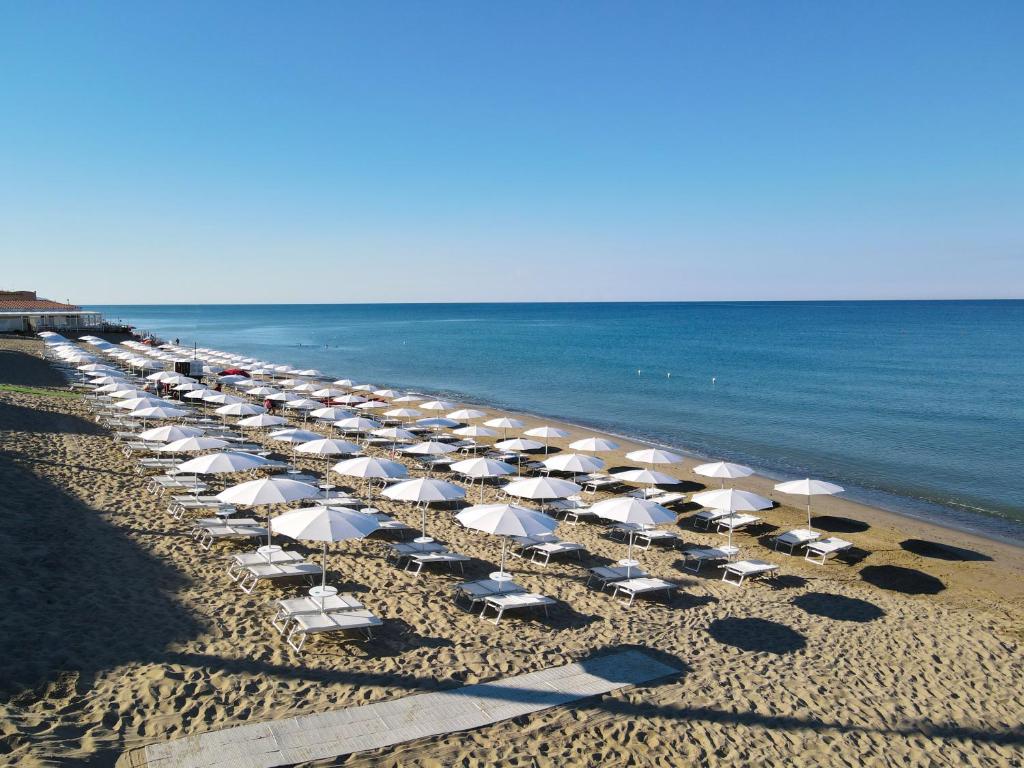une rangée de chaises et de parasols sur une plage dans l'établissement Eleamare Resort, à Castellammare di Velia