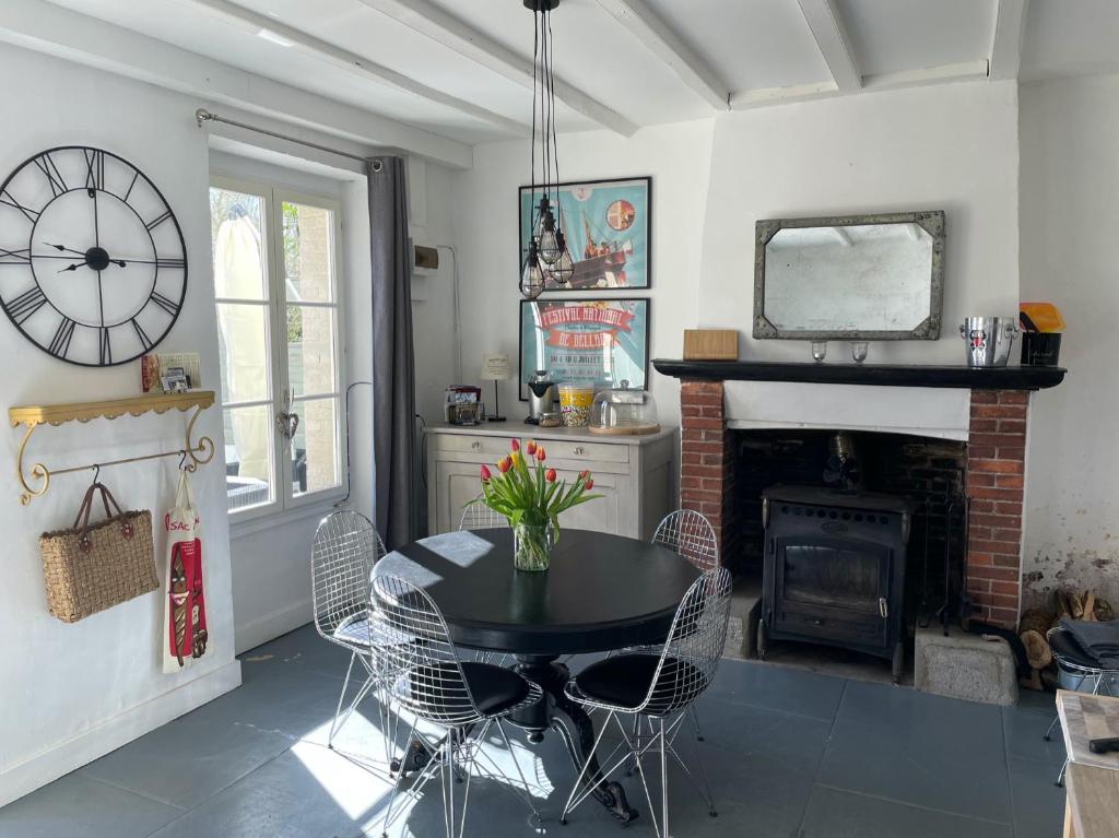 une salle à manger avec une table et une cheminée dans l'établissement Maison Hirondelles Gîtes, à Mézières-sur-Issoire