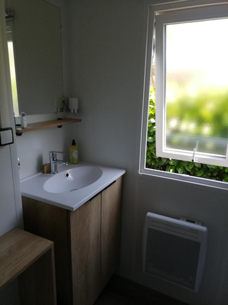 une salle de bain avec un lavabo et une fenêtre dans l'établissement MOBILHOME GASTES LANDES, à Gastes
