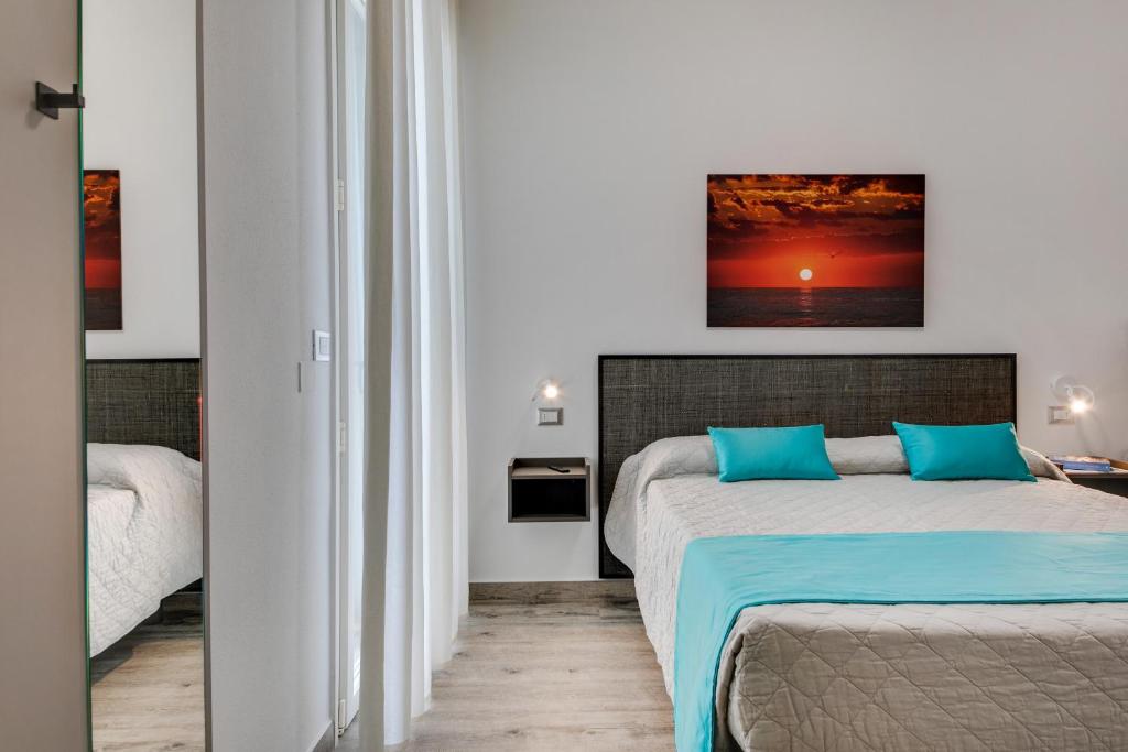 une chambre avec deux lits et un tableau au mur dans l'établissement Elegance Suite Apartments - Siroli Collection, à Cervia